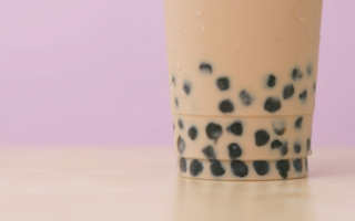 Up close image of bubble iced tea with pink background.