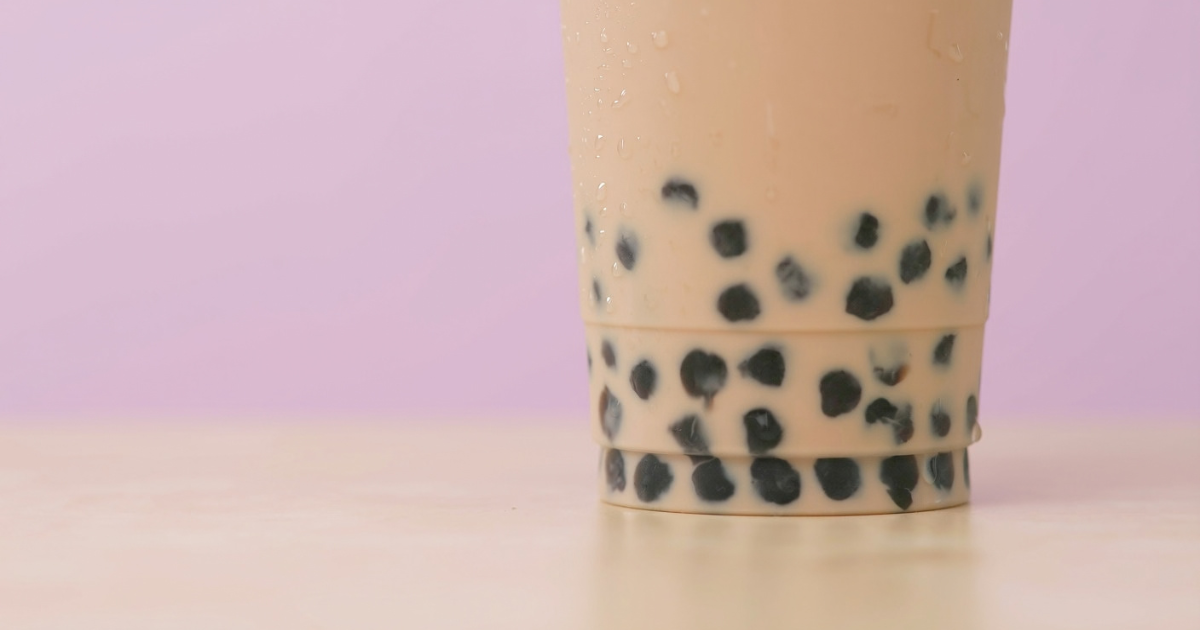 Up close image of bubble iced tea with pink background.