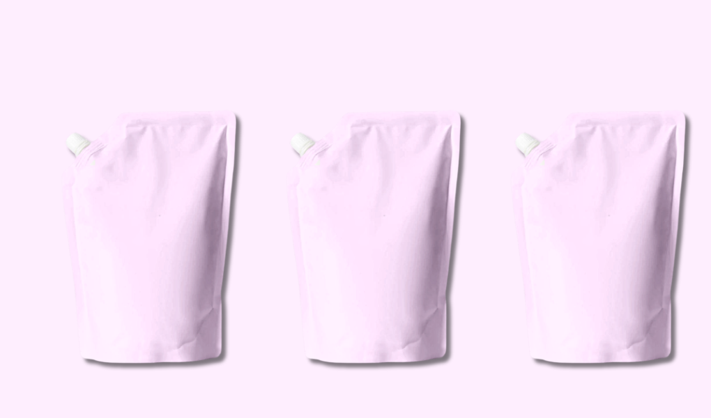 Three identical pink shampoo refill pouches arranged on solid pink background showcasing sustainable hair care packaging