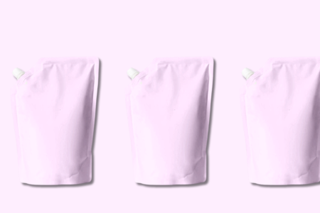 Three identical pink shampoo refill pouches arranged on solid pink background showcasing sustainable hair care packaging
